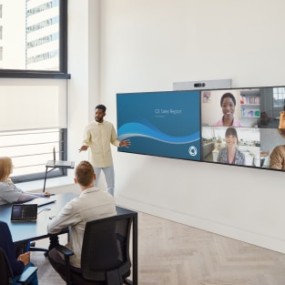 Collaboration on Microsoft Teams between in-person and remote colleagues in a meeting room with the Cisco Room Kit Plus mounted on dual displays.